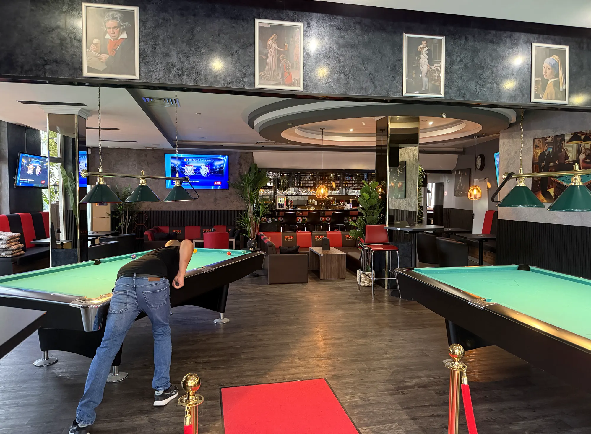 Ein Gast beim Stoß am Billardtisch in der Players Lounge Dorsten, im Hintergrund Bar und Lounge